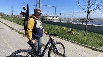 A man standing with an electric bike and a eoSLAM ZEB Horizon laser scanner