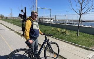 A man standing with an electric bike and a eoSLAM ZEB Horizon laser scanner