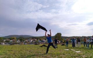 A person is on a field letting go of a drone