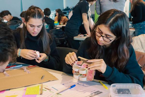 Two young people working on assembling a form of model figure